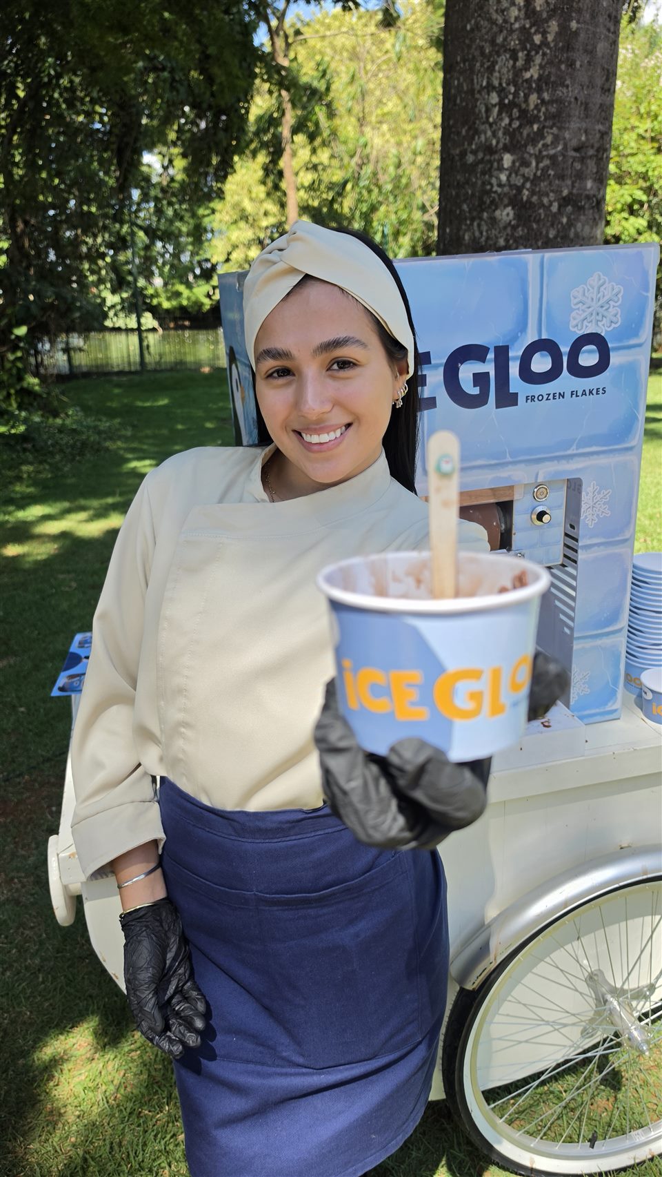 Profissional IceGloo com copo de sorvete junto à estrutura de atendimento em evento